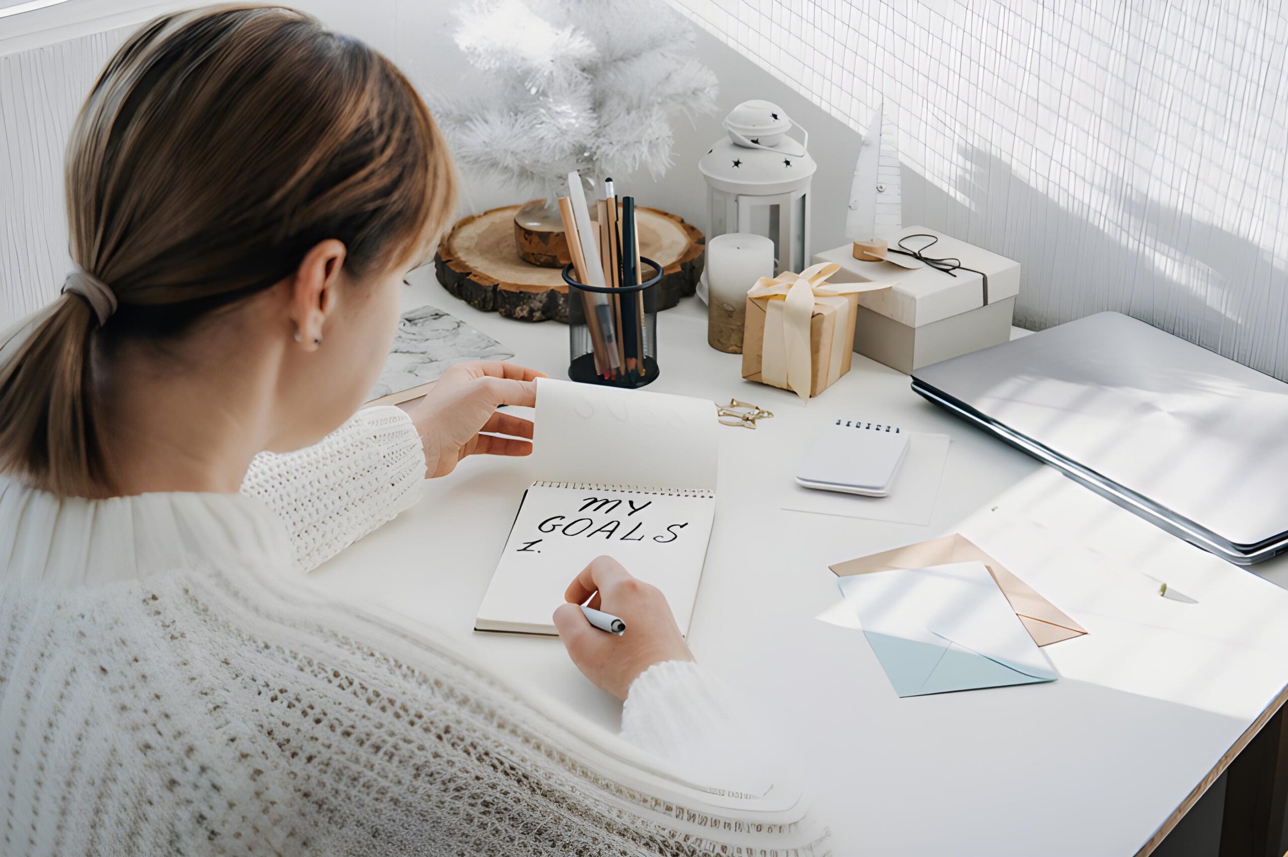 A woman sitting at a desk, thoughtfully writing down her financial goals in a notebook, focused and determined.